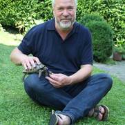 Dr. Ganal füttert eine Schildkröte im Garten