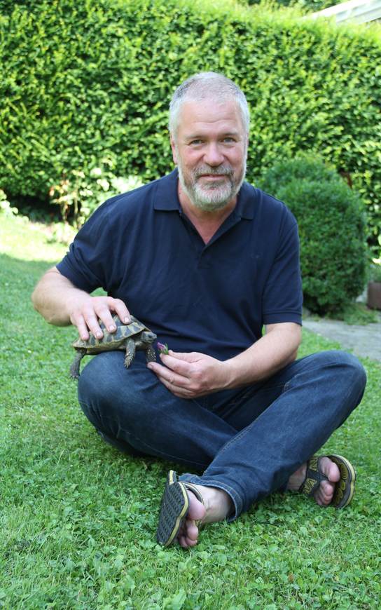 Dr. Ganal füttert eine Schildkröte im Garten
